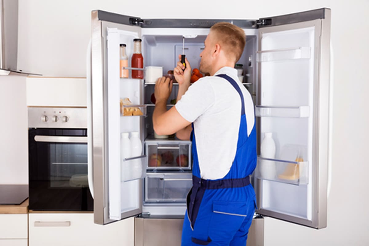 Técnico de Rapid Services reparando una nevera en una cocina de La Orotava