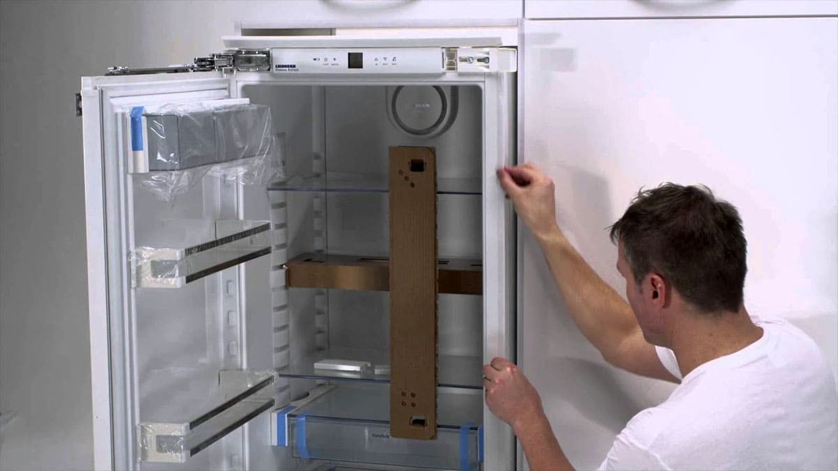 Técnico de Rapid Services revisando un frigorífico en un apartamento de Santiago del Teide